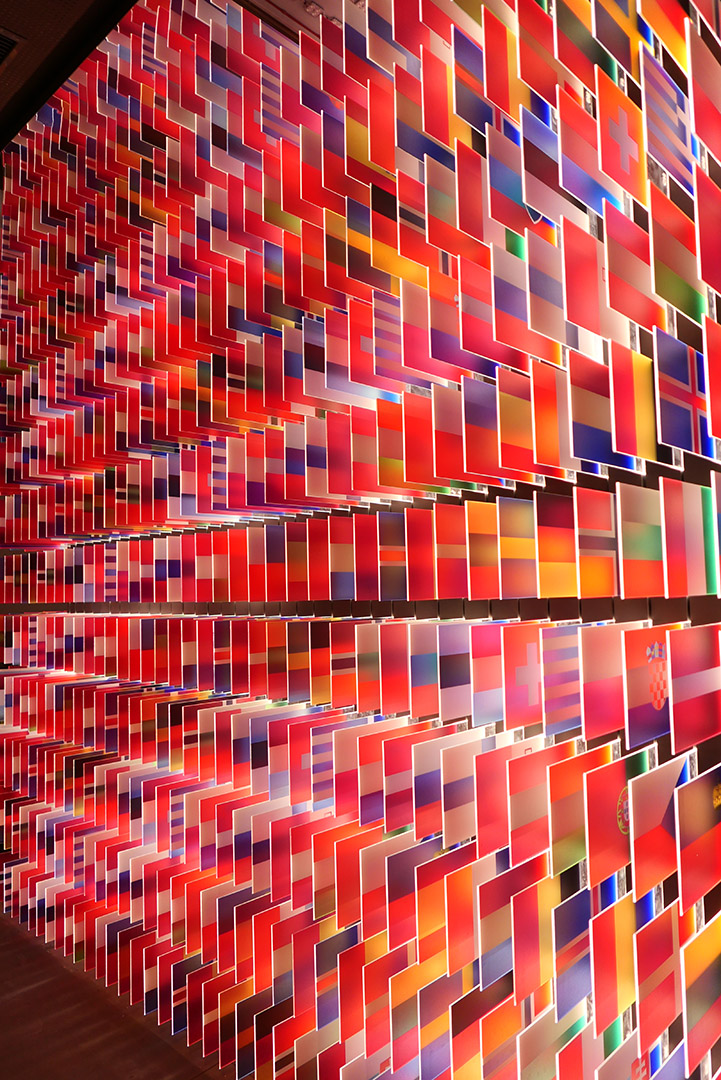 Colorful wall of lit national flag tiles, with a lot of red